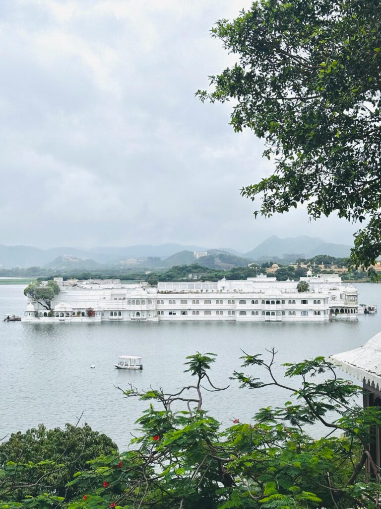 Picturesque view of the Lake Palace surrounded by tranquil waters in Udaipur, India.(Luxury Travel in Rajasthan)