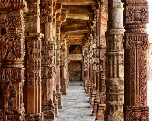 Explore the detailed stone carvings on historic architectural pillars in this ancient corridor.